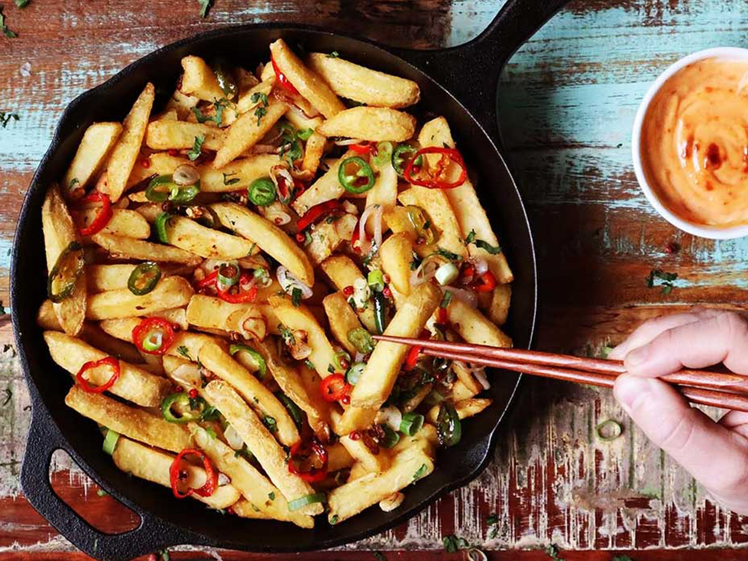 Seasoned chips with sliced chillies served in a cast-iron pan